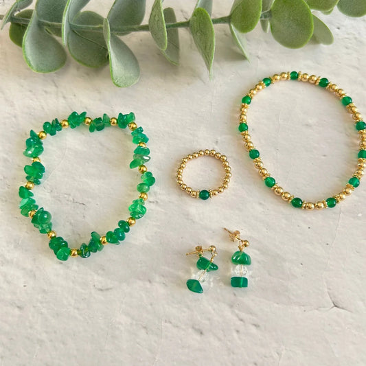 Handmade green agate jewellery set featuring two bracelets, a beaded ring, and gemstone drop earrings – a meaningful May birthstone gift set styled with eucalyptus.