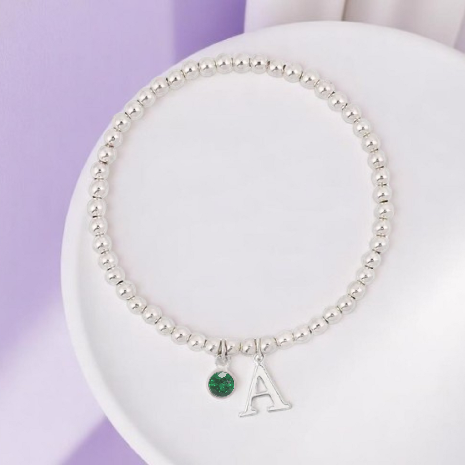 Sterling silver personalised bracelet with emerald May birthstone charm and initial letter pendant – a handcrafted stretch bracelet gift for her.