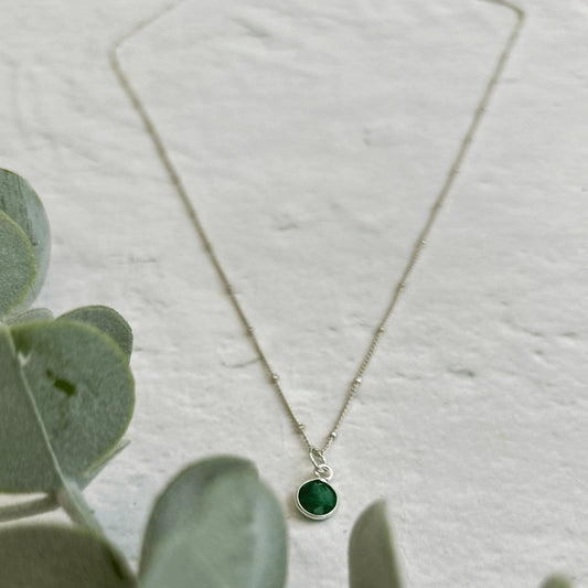 Sterling silver necklace with emerald green birthstone charm – a dainty May birthstone pendant necklace.