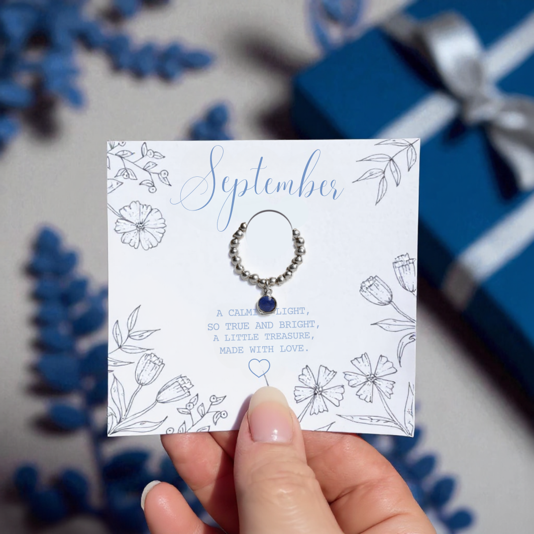 a thoughtful september birthstone gift for friends, daughter or september born girlies, a sterling silver stretchy bead ring with a blue sapphire charm