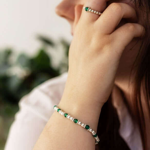 Woman wearing a green gemstone ring with sterling silver beads and matching bracelet – part of a meaningful handmade jewellery set.