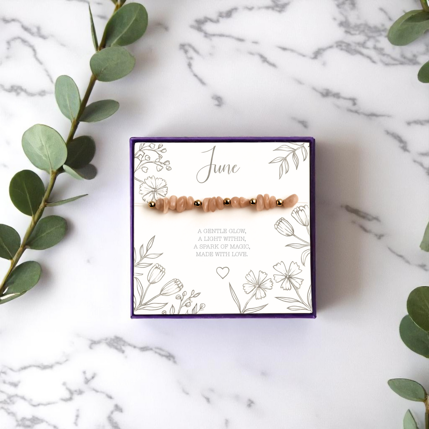 Handmade June birthstone bracelet with peach moonstone crystal chips and gold accent beads, presented on a floral message card in a purple gift box. A calming stretch bead bracelet and meaningful handmade gift for her.