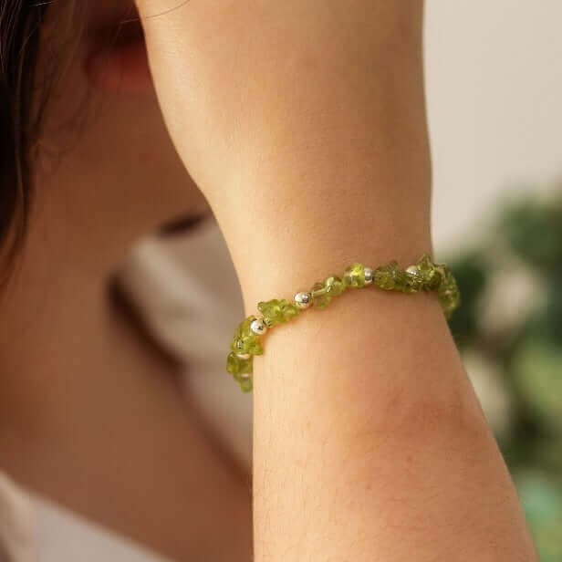 Close-up of peridot crystal stacking bracelet on wrist, handmade gift for her
