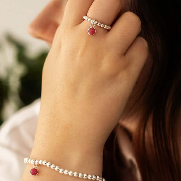 Handmade sterling silver ruby birthstone ring styled on hand, paired with matching bracelet for a meaningful July gift look.