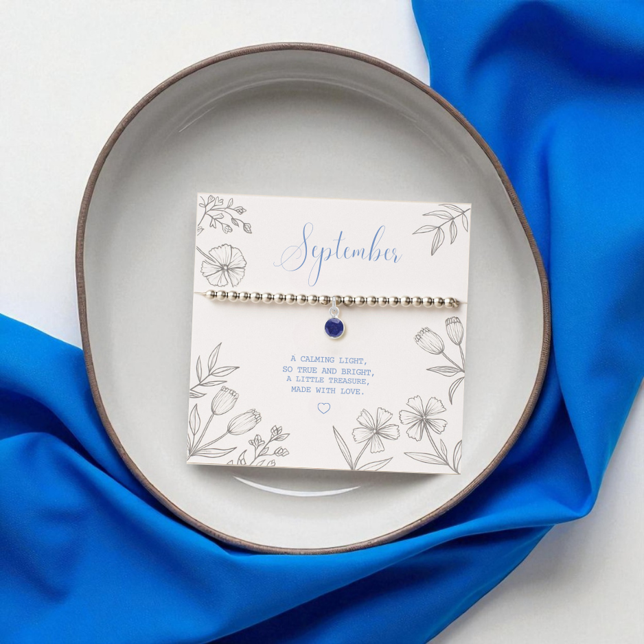 a sterling silver stretchy bead bracelet with a september birthstone charm. a charm bracelet with a sapphire birthstone charm is a beautiful gift for her.
