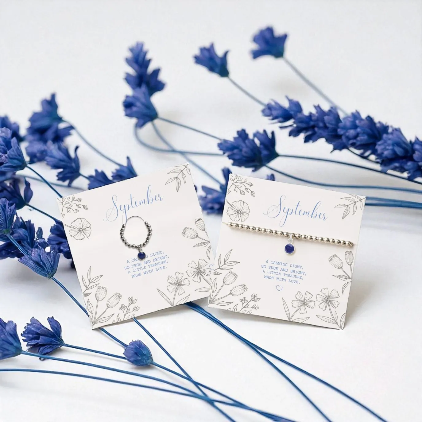 Made Here With Love September birthstone jewellery gift set featuring sapphire charm bracelet and beaded ring on illustrated message cards with floral design, meaningful handmade birthday gifts for women UK.