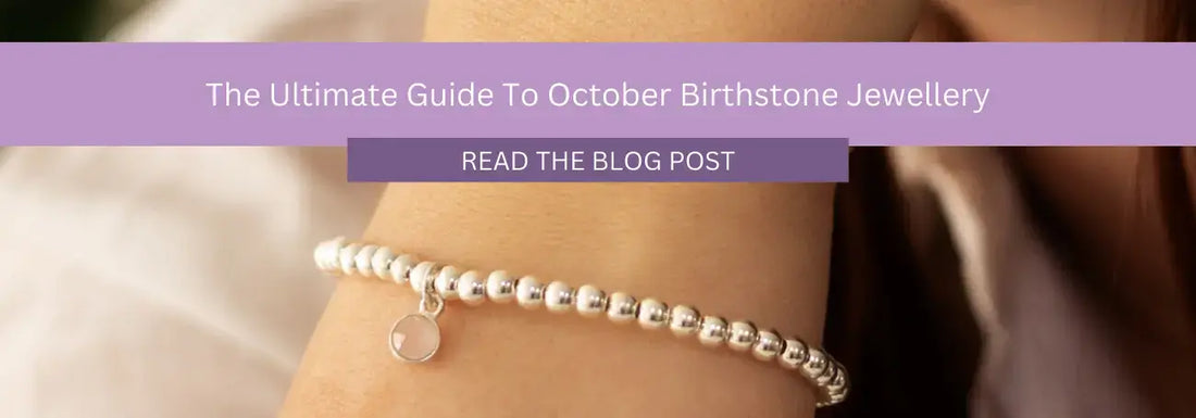 A close-up image shows a person's wrist adorned with a silver beaded bracelet featuring a small round charm. Above the wrist is a purple banner with the text: "The Ultimate Guide To October Birthstone Jewellery" and a button labeled "Read The Blog Post.