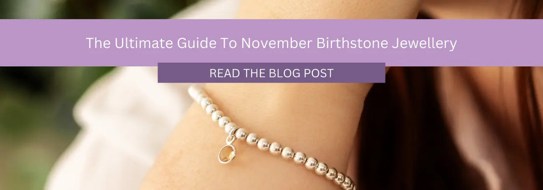  A banner image featuring a person's wrist adorned with a silver beaded bracelet, highlighting a ring charm. The text reads, "The Ultimate Guide to November Birthstone Jewellery" and includes a button labeled "Read the Blog Post.