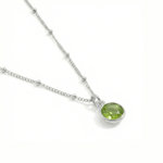 August birthstone peridot necklace in sterling silver, featuring a soft green gemstone.