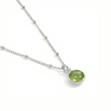 August birthstone peridot necklace in sterling silver, featuring a soft green gemstone.