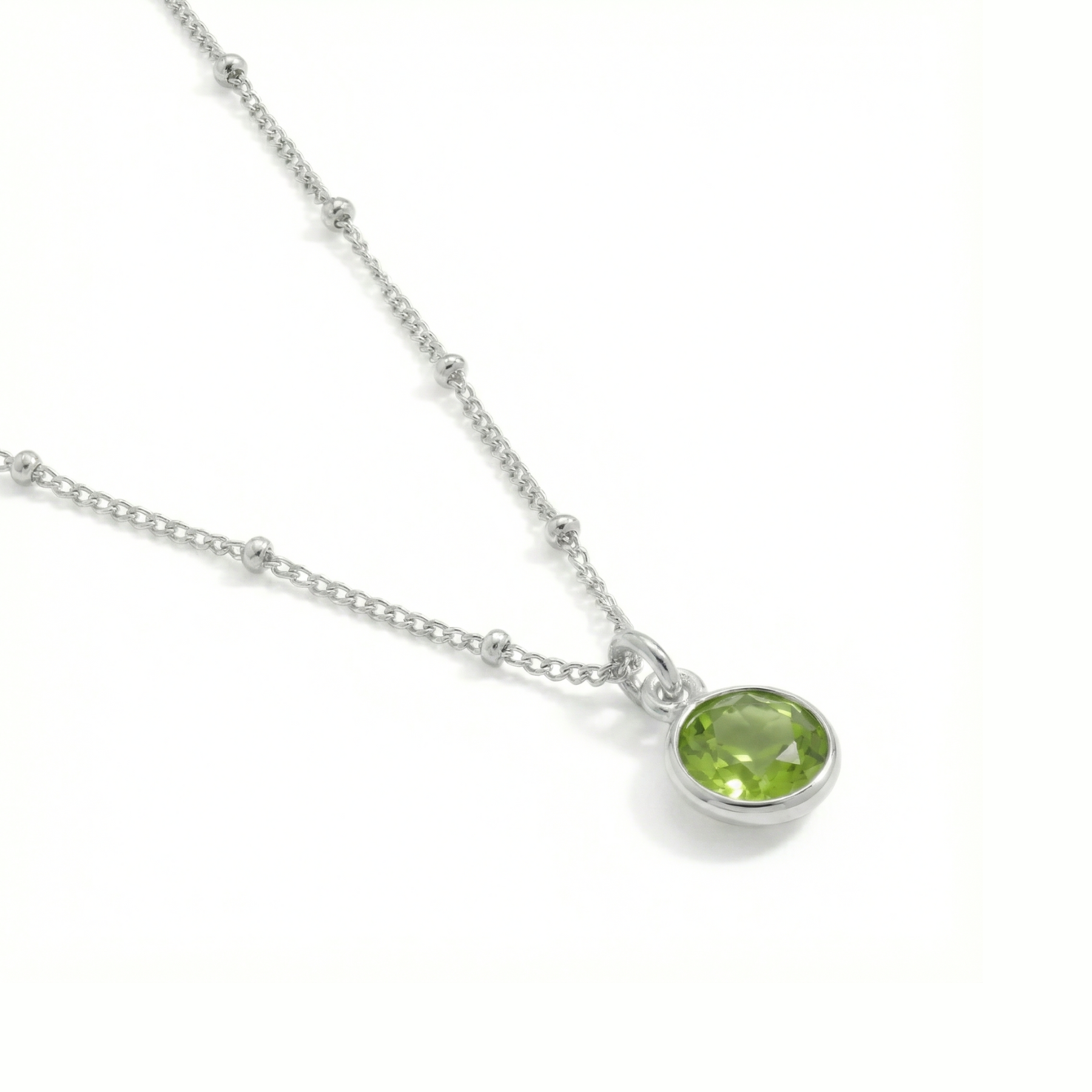 August birthstone peridot necklace in sterling silver, featuring a soft green gemstone.