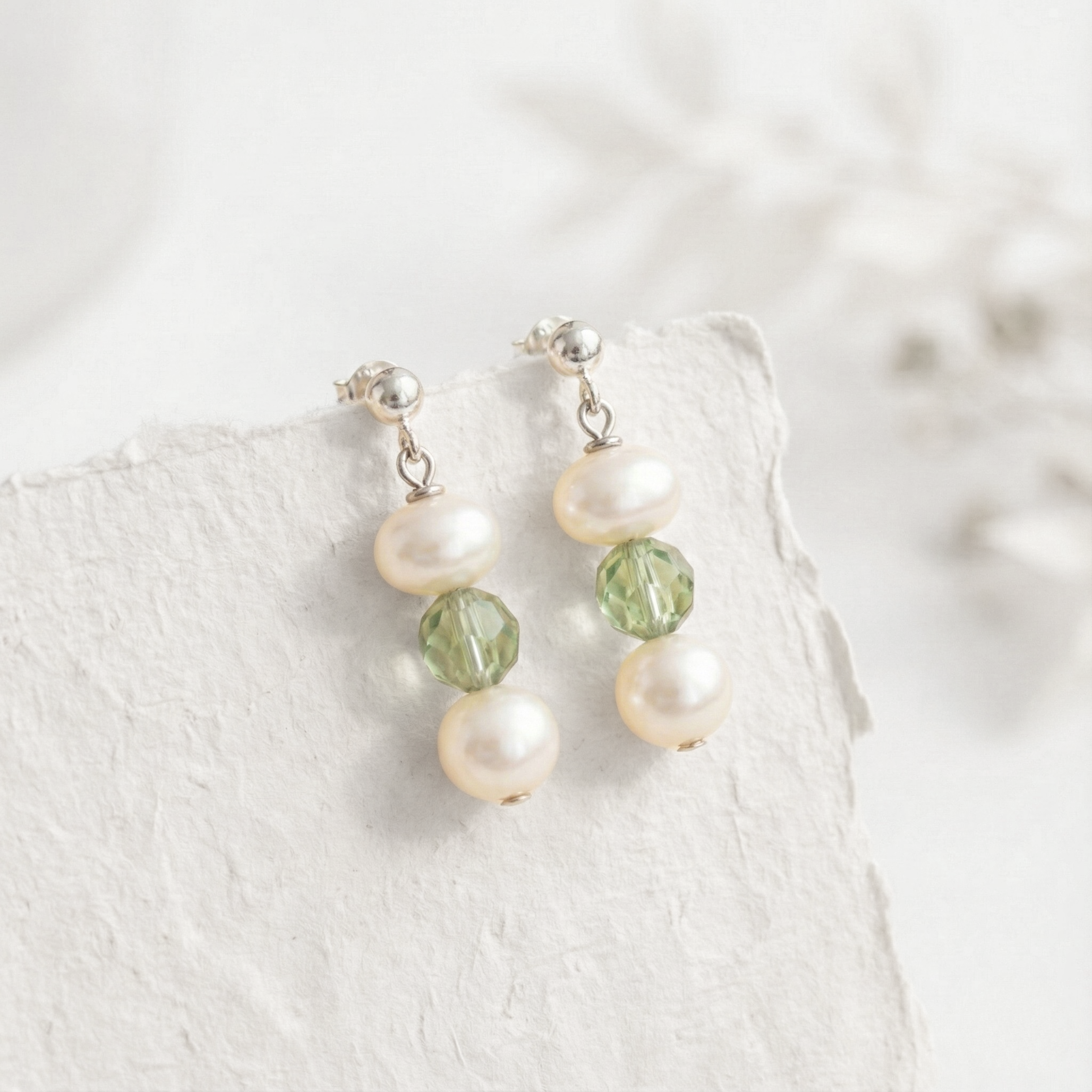 August birthstone earrings with peridot gemstones and pearl details in a delicate drop style.