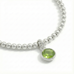 August birthstone stretch bead bracelet with peridot charm, featuring sterling silver beads and green gemstone.