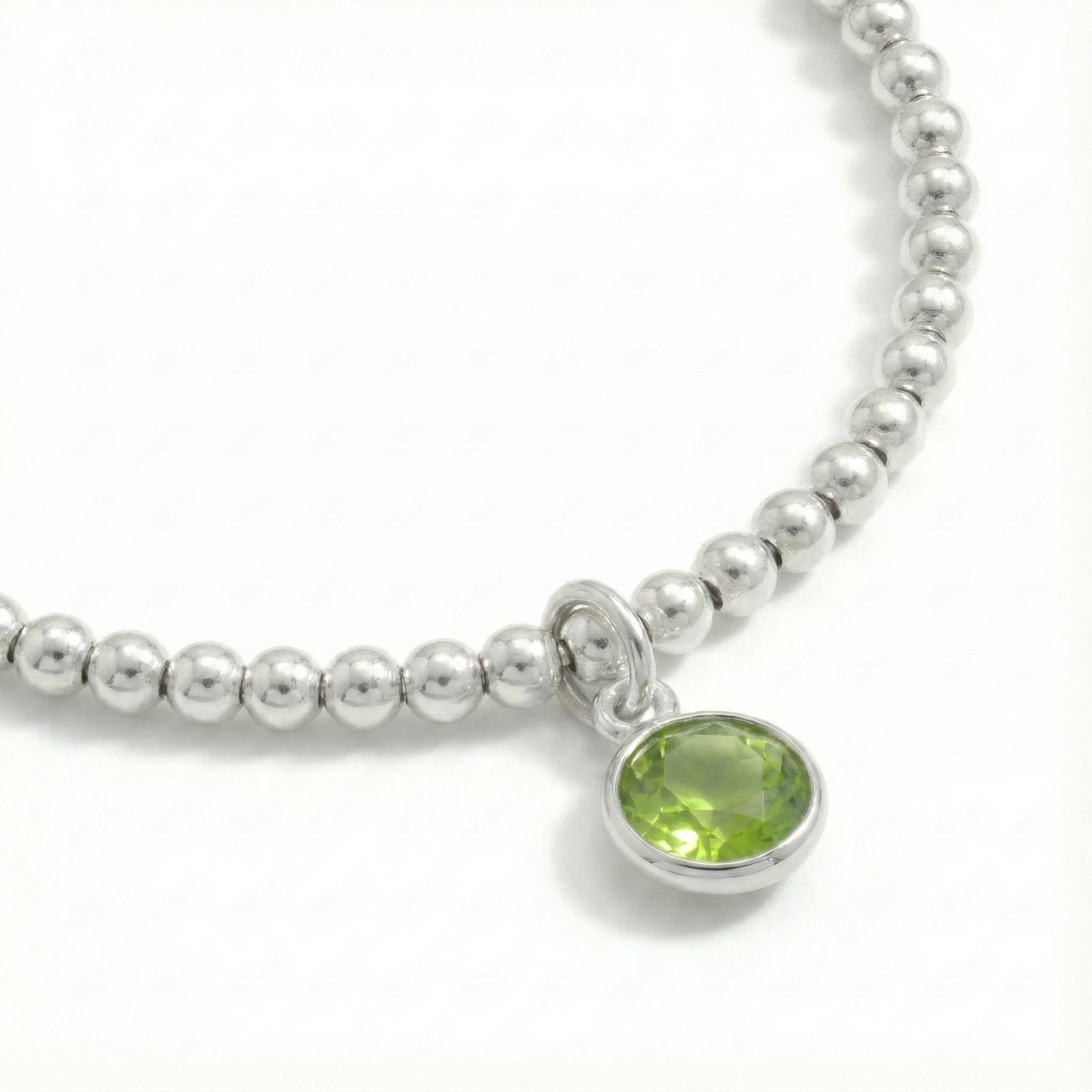 August birthstone stretch bead bracelet with peridot charm, featuring sterling silver beads and green gemstone.