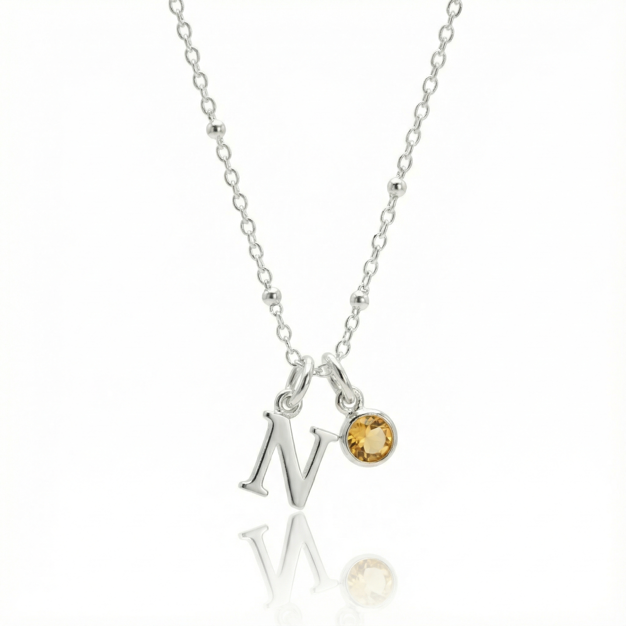 Citrine birthstone and letter charm necklace in sterling silver with golden yellow gemstone.