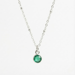 May birthstone emerald charm necklace featuring a deep green gemstone on a sterling silver chain.