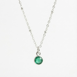 May birthstone emerald charm necklace featuring a deep green gemstone on a sterling silver chain.