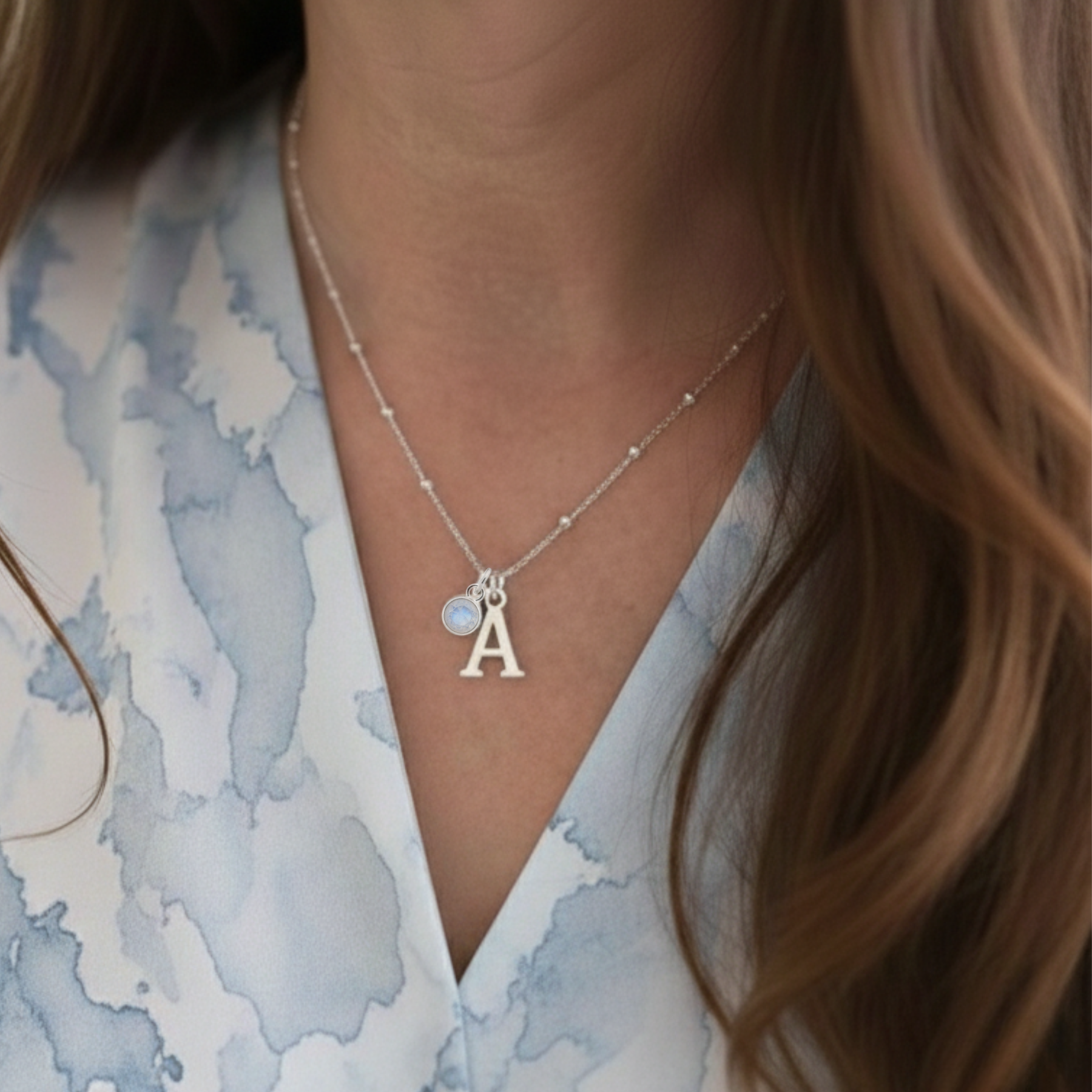 June birthstone moonstone necklace with personalised initial letter charm in sterling silver, meaningful custom jewellery gift.