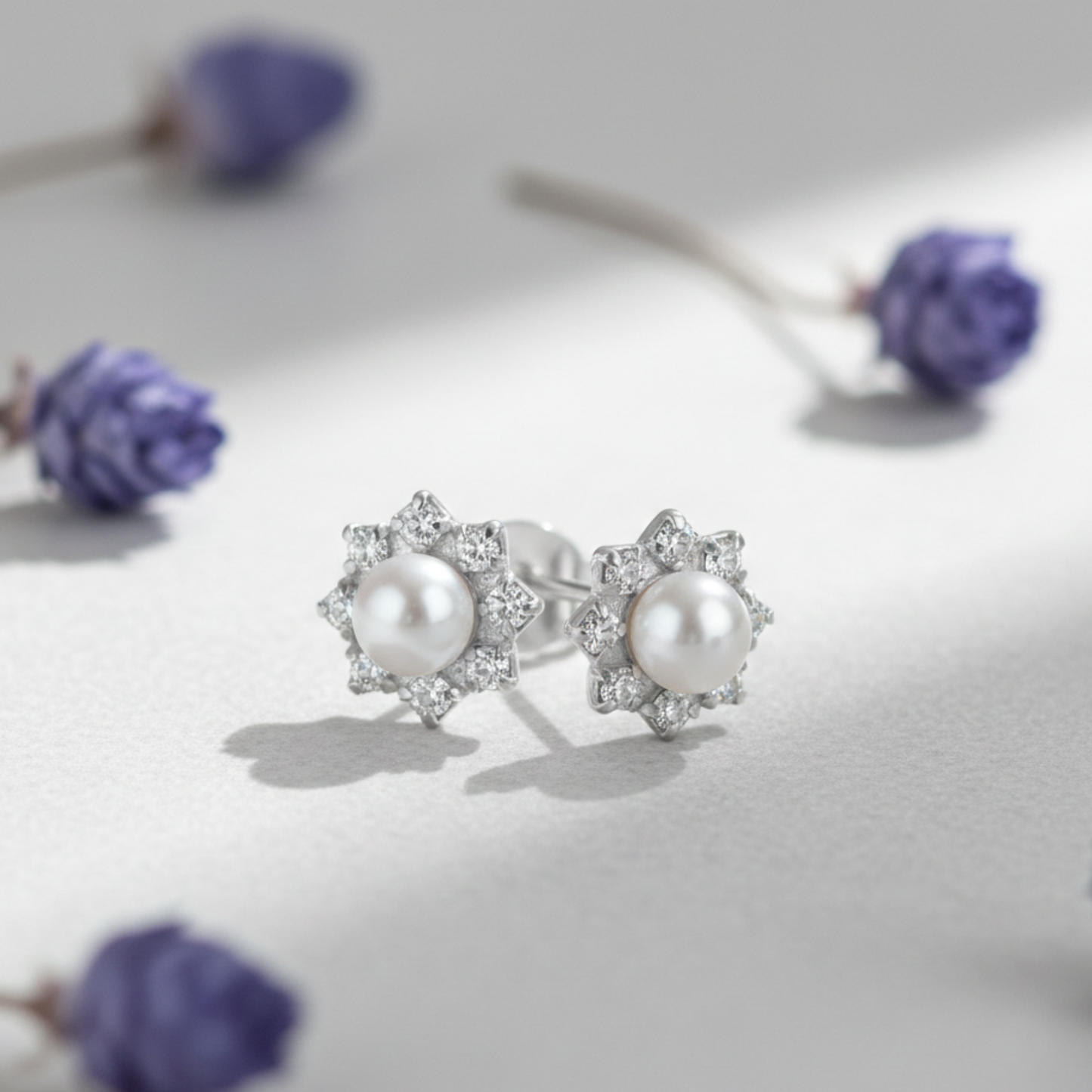 Sterling silver pearl and crystal stud earrings featuring luminous pearls and sparkling cubic zirconia, classic bridal or occasion jewellery.