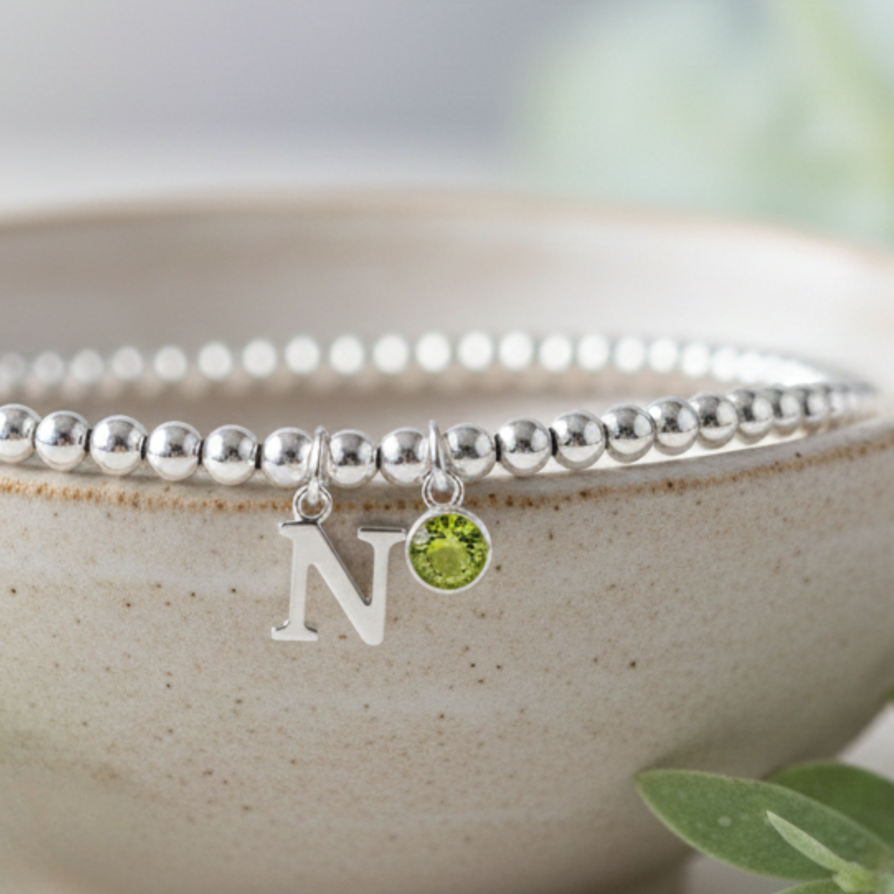 Personalised peridot bracelet with initial charm in sterling silver, August birthstone jewellery gift for her.