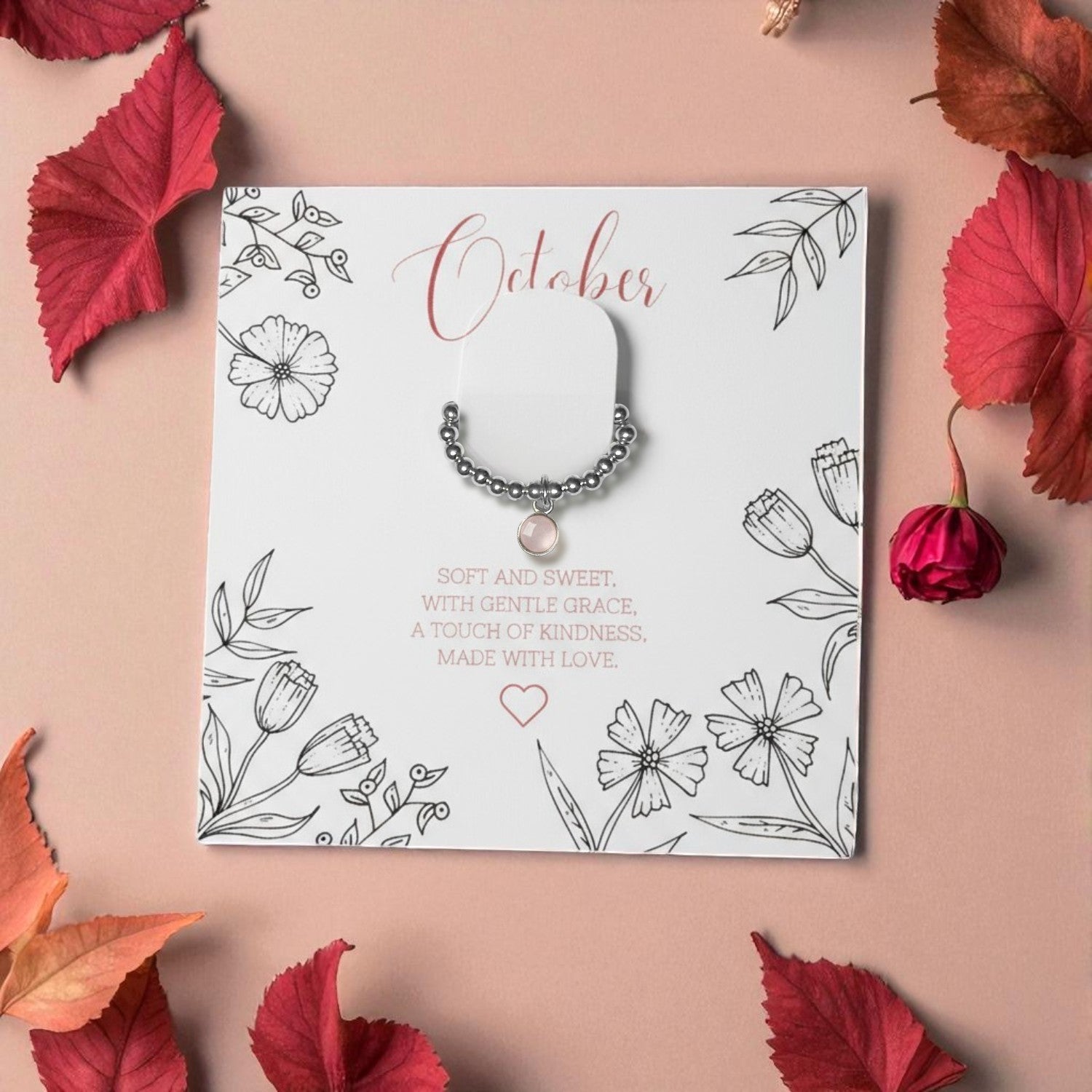 Rose Quartz Birthstone Ring on October birthstone message card with sterling silver beads and rose quartz charm, surrounded by autumn leaves