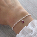 Ruby charm bracelet for July birthstone with sterling silver beaded stretch design UK