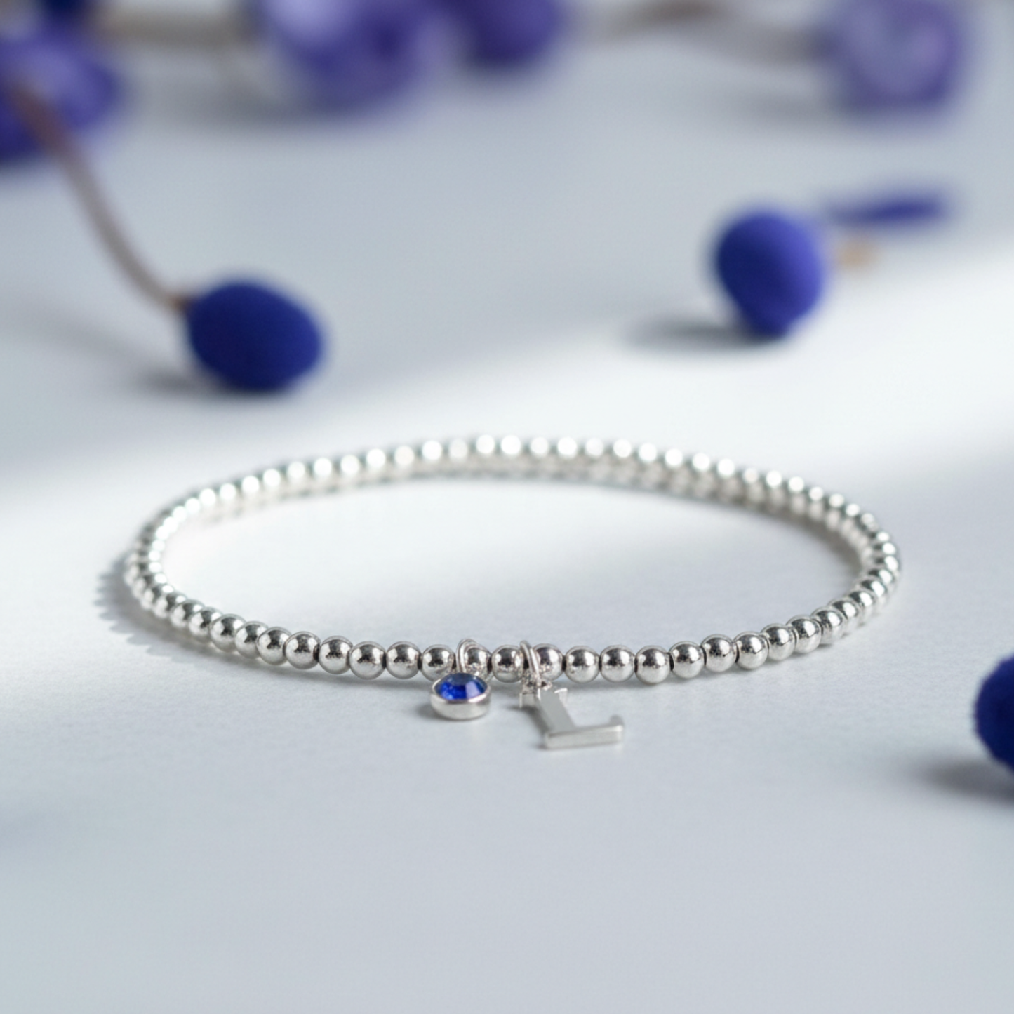 September sapphire charm bracelet with personalised initial in sterling silver, custom birthstone jewellery gift.