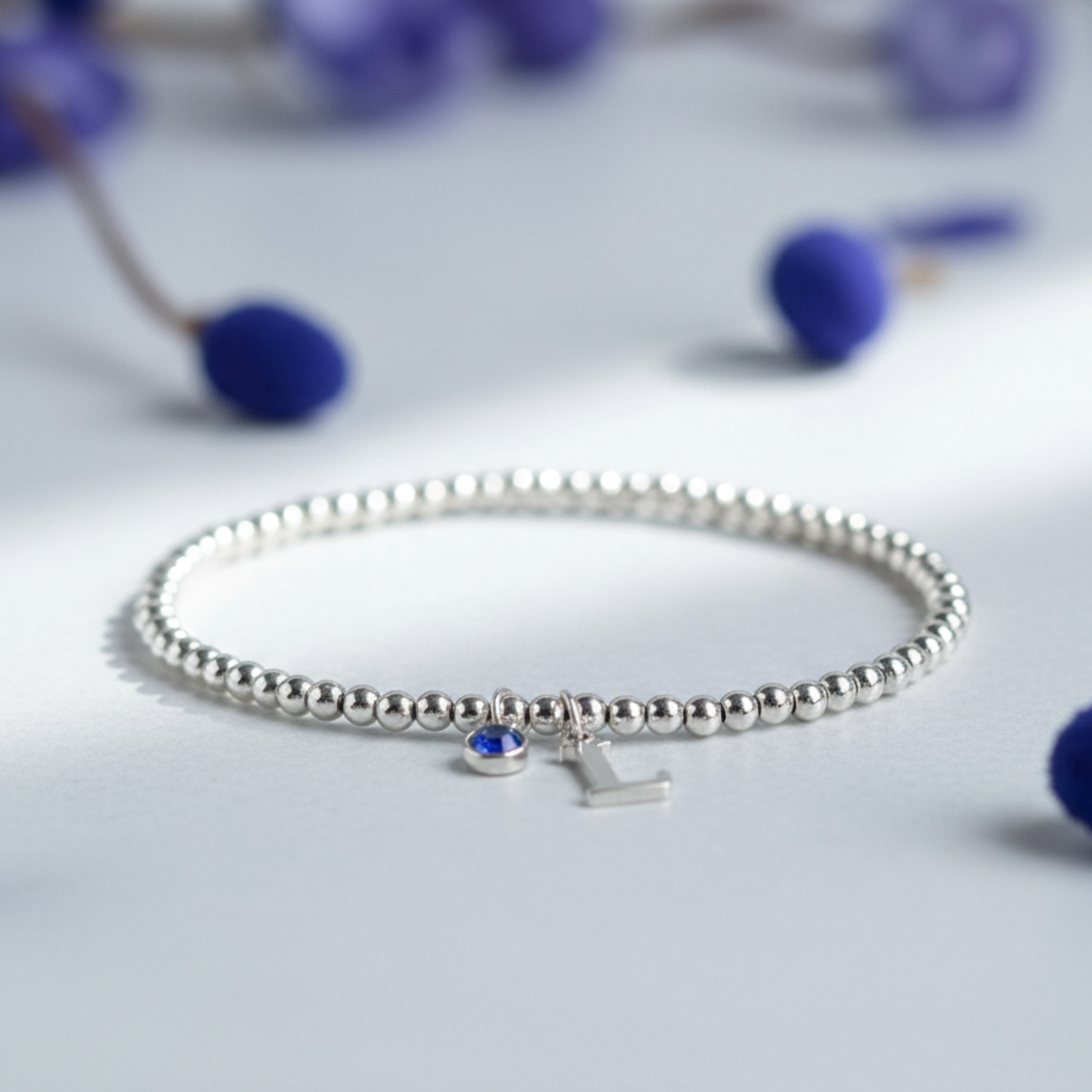 September sapphire charm bracelet with personalised initial in sterling silver, custom birthstone jewellery gift.
