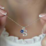 September sapphire birthstone necklace with initial charm worn on neck, personalised sterling silver jewellery gift.